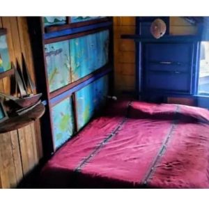 a small bedroom with a red bed in a room at Kismet Inn Semi Private in Hopkins