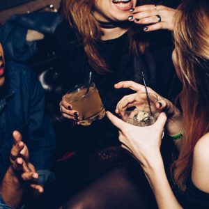 friends cheering cocktails bar night — photo by Michael Discenza on Unsplash
